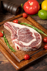 Veal chop. Fresh beef raw thick ribs with spices and rosemary. Special cutlet. wood background. Close up