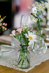 Fototapeta na wymiar Sommerliche Blumen als Tischdeko in kleiner Vase