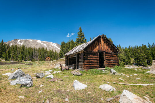 Log cabin on field against blue sky