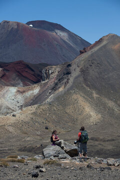 Hikers against mountains at desert during sunny day