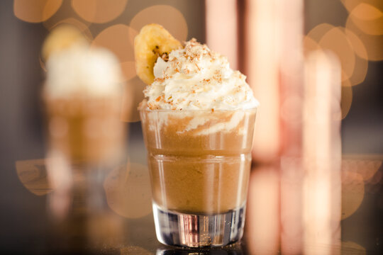 Close-up of sweet food in shot glass on table against bokeh