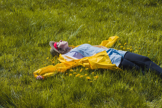 Carefree young woman lying on grassy field at park