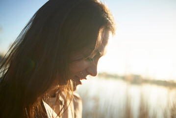 Close-up of thoughtful young woman against sky during sunset
