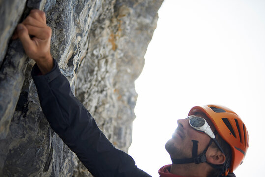 Hiker wearing helmet while climbing mountain