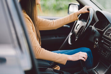 Midsection of woman driving car seen through window