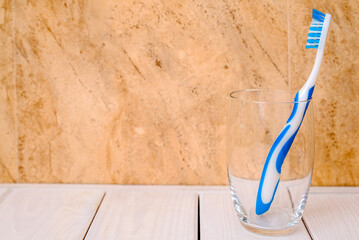Toothbrush stands in a glass on a beige background
