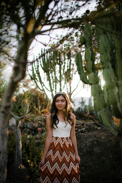 Teenage girl wearing tiara while looking away against cactus in garden during Quinceanera