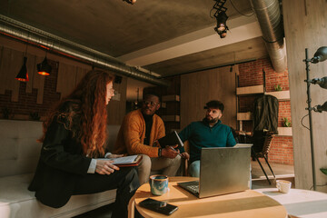 Redhead female person talking to her male multiracial coworkers while working together remotely
