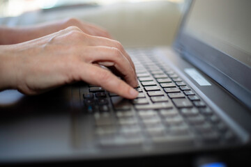 Close up of fingers working on a laptop