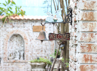 Welcome sign in the cafe is hanging from a brick wall.