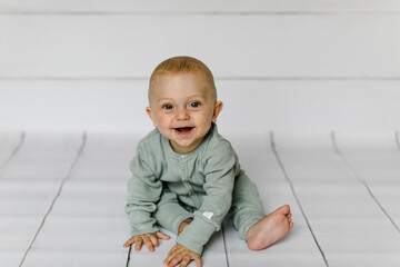 Lachender Junge sitzt am Boden 