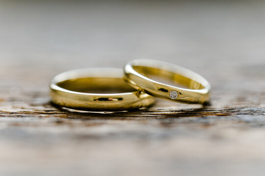 Klassische Eheringe in gold auf Holz