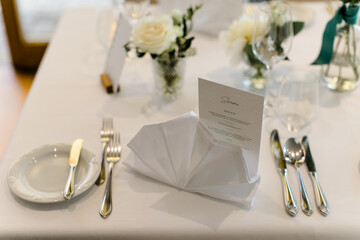 Edler Hochzeitstisch mit weißen Stoffservietten bei Hochzeitsfeier im Restaurant beim...