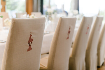 Edler Hochzeitstisch mit weißen Stuhlhussen bei Hochzeitsfeier im Restaurant in Kitzbühel mit Gams