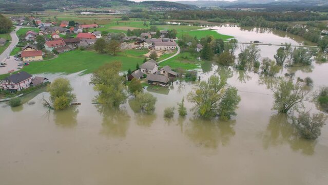 AERIAL: Autumn flood water came dangerously close to the residential houses. Large agricultural area submerged under muddy raised river water. Autumn flood in the countryside after heavy rainfall.