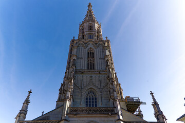 Fototapeta premium Looking up tower of Berner Münster church at the old town of City of Bern on a sunny winter day. Photo taken February 21st, 2023, Bern, Switzerland.
