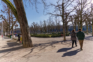 Fototapeta na wymiar Scenic view of tree alley at Minster Terrace at the old town of Swiss City of Bern with tourists on a sunny winter day. Photo taken February 21st, 2023, Bern, Switzerland.
