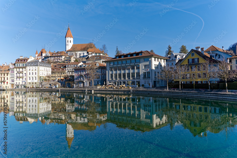 Wall mural Scenic view of Aare River with the old town of Swiss City of Thun and castle and church on a hill on a sunny winter day. Photo taken February 21st, 2023, Thun, Switzerland.