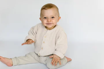 Fotobehang Lachender kleiner Junge sitzt und lacht fröhlich © freudelachenliebe