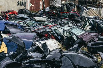 A dump of broken rusted cars, their parts and tires
