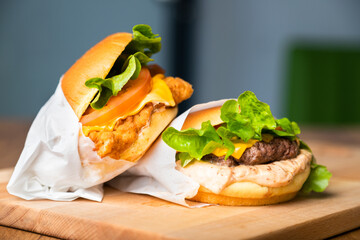 Cheese burger - American cheese burger with fresh salad on wooden board