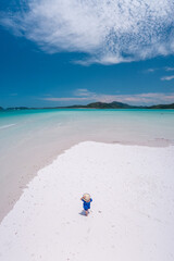 Aerial view of a woman standing on the beautiful Whitehaven  Beach in the Whitsundays