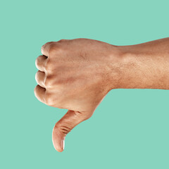 Hand, thumbs down and negative emoji with a man in the studio on a green background for...