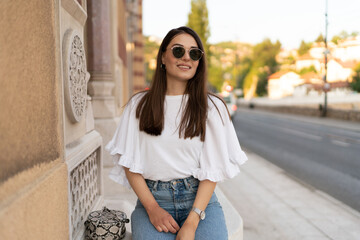 Fototapeta premium Young smiling charming woman portrait in the city