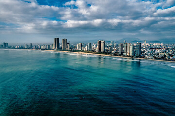 Coastline of Da Nang Vietnam in the morning, skyscrapers with clouds in the sky and stunning blue green color in the sea 