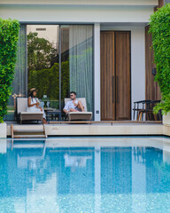 Luxury 5 star hotel pool in Asia. A couple of men and women on vacation at a luxury hotel resort, men and women by the pool in the evening