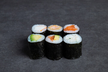 Sushi rolls on a black background, close-up, top view