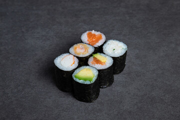 Sushi rolls on a black background, close-up, top view