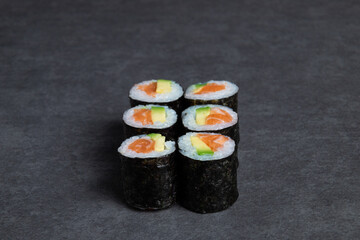 Sushi rolls on a black background, close-up, top view