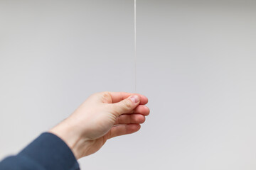 Man hand pulling small wire string of a lamp