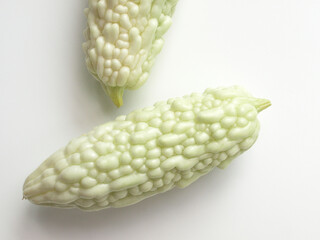 白背景に白いゴーヤが２本、夏の野菜のゴーヤ、室内のゴーヤ