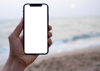 Hand holding black smartphone with transparent screen and beach see background , smartphone frameless application design concept and PNG file