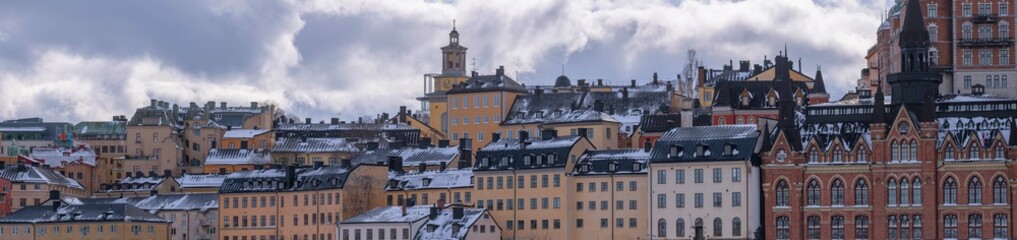 Fototapeta na wymiar Panorama, old hoses block at the street Bastugatan and the vista point Monteliusvägen, a snowy day in Stockholm