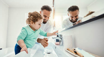 Cleaning, washing hands and father with baby in bathroom for hygiene, wellness and healthcare at home. Family, skincare and dad with child learning to wash with water, soap and disinfection by faucet