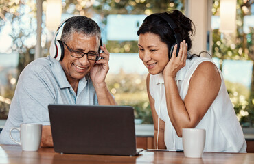 Laptop, headphones and senior couple on video call in home, chatting and talking. Technology, computer and happy, elderly and retired man and woman in virtual conversation or online streaming