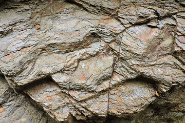 A hewn brown and orange sedimentary rock containing sulfur and pyrite