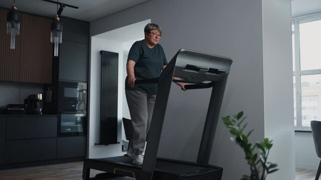 Cardio Training On Treadmill At Home, Aged Overweight Woman Walking For Keeping Fit