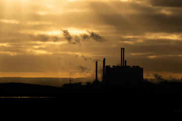 Fototapeta na wymiar Factory with smoking chimneys at sunset