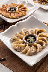 Portions of steamed and fried chinese dimsam dumplings with sauce