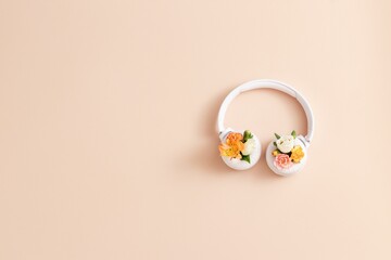 White headphones for listening to music on beige background . Pantone color 2024. Peach fuzz