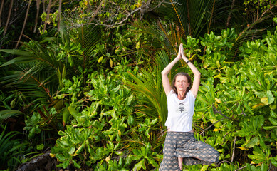 woman doing yoga on tropical beach