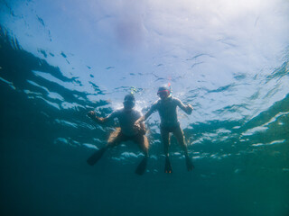 couple snorkeling in clear tropical sea