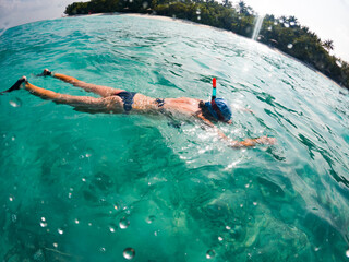 woman snorkeling in clear tropical sea