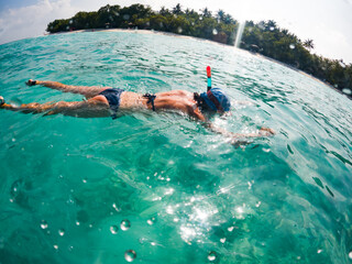 woman snorkeling in clear tropical sea