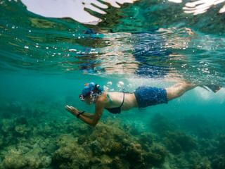 Obraz na płótnie Canvas woman snorkeling in clear tropical sea