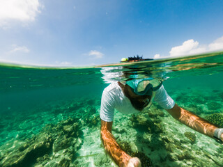 man snorkeling in crystal clear tropical sea